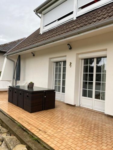 a house with a patio with a table in front of it at Helene in Torcy