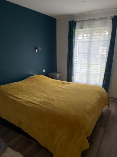 ein Schlafzimmer mit einem gelben Bett und einem Fenster in der Unterkunft Helene in Torcy