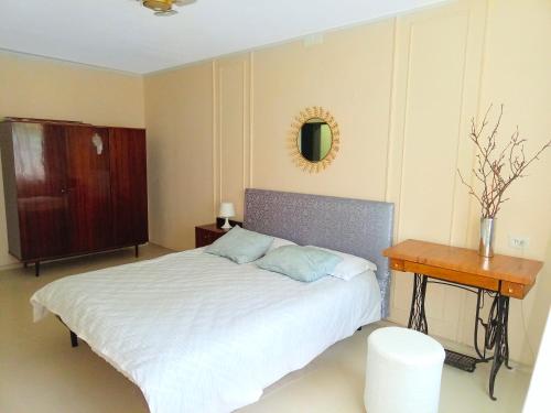 Schlafzimmer mit einem Bett, einem Tisch und einem Spiegel in der Unterkunft Квартира трехкомнатная в Орбите 3 на первом этаже in Almaty