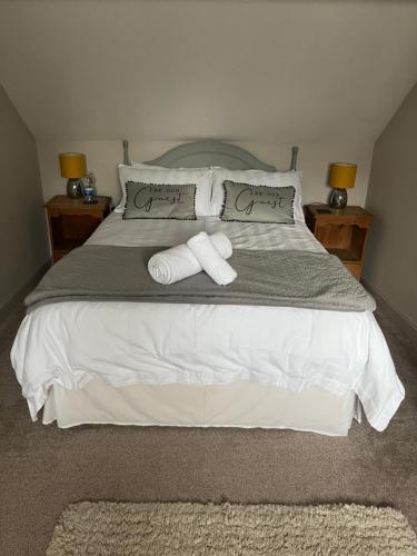 a bedroom with a bed with two towels on it at The Old Coach House at BYRE HOUSE 