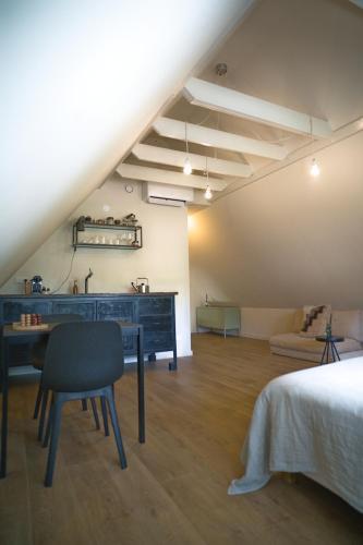 an attic room with a desk and a bed at WetterLoft - Luxe appartement met aanlegsteiger en terras in Terherne