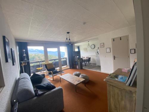 sala de estar con sofá y mesa en Appartement 50m2 vue imprenable avec garage draps et serviettes compris en Villard-de-Lans
