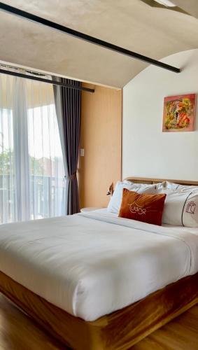 a large white bed in a room with a window at Tuong Boutique Mui Ne in Mui Ne