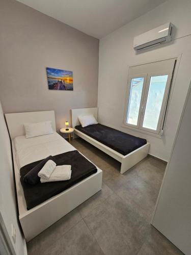 um quarto com 2 camas e uma janela em Villa Sakrakis seaview villa em Stavros