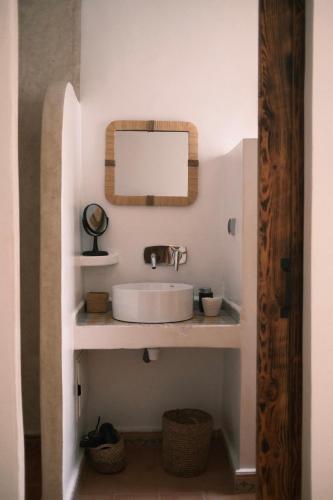 a bathroom with a sink and a mirror at Riad Bianca Essaouira Guest House in Essaouira