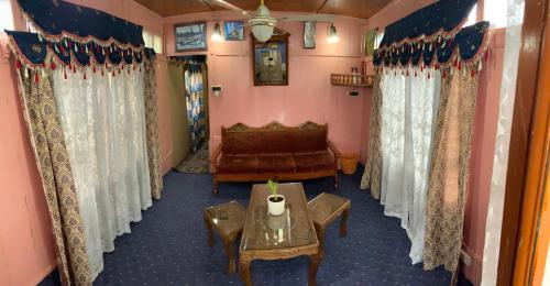 a living room with a couch and a table at Movie land group of house boats in Srinagar