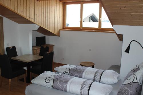um quarto com três camas e uma mesa e uma janela em Ferienwohnungen Walserhof Malbun em Malbun