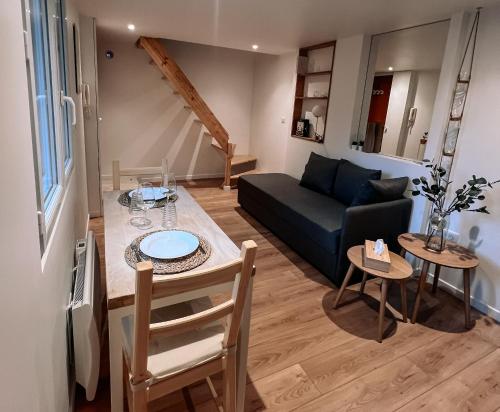 un salon avec un canapé et une table dans l'établissement Petite maison avec jardin à Paris, à Aubervilliers