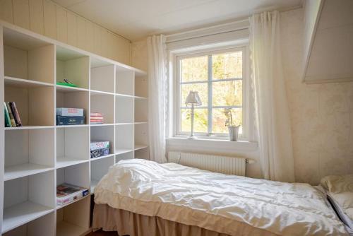 a bedroom with a bed and a window and shelves at Outstanding apartment close to Gothenburg in Kungälv