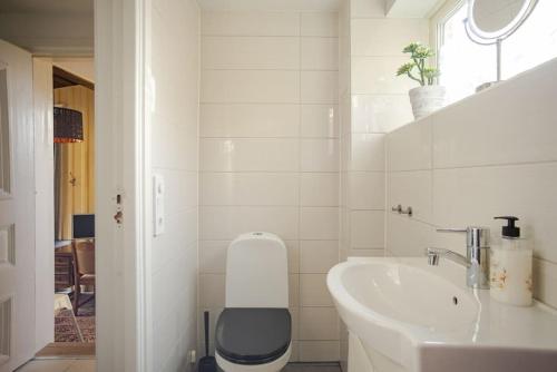 a white bathroom with a toilet and a sink at Outstanding apartment close to Gothenburg in Kungälv