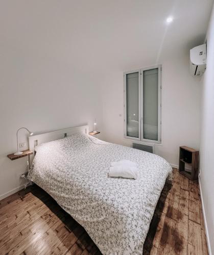 une chambre blanche avec un lit et une fenêtre dans l'établissement Petite maison avec jardin à Paris, à Aubervilliers