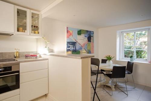 a kitchen with a table and a table and chairs at Outstanding apartment close to Gothenburg in Kungälv