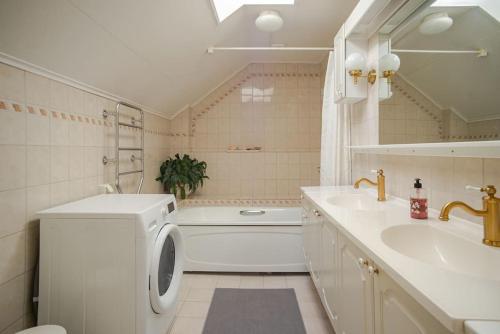a bathroom with a washing machine and a sink at Outstanding apartment close to Gothenburg in Kungälv