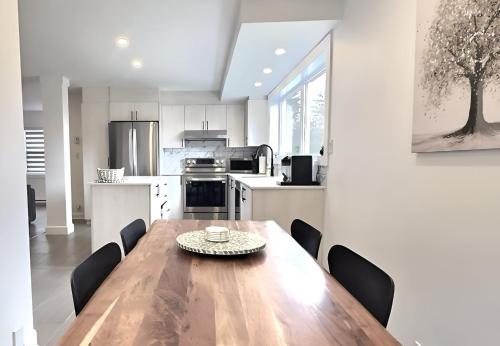 a large kitchen with a wooden table and chairs at Le domaine du Sous-Bois in Mont-Blanc