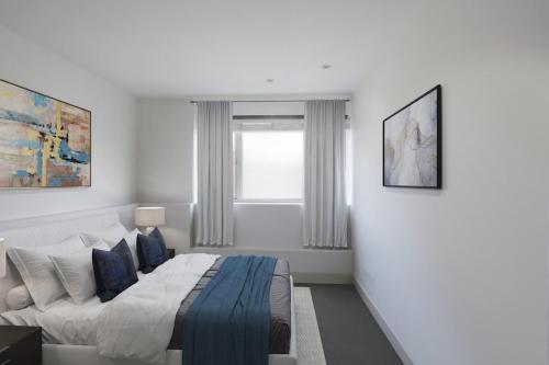 a white bedroom with a bed and a window at Comfy 2 Bedrooms by Natural History Museum in London