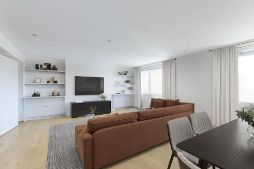 a living room with a couch and a tv at Comfy 2 Bedrooms by Natural History Museum in London