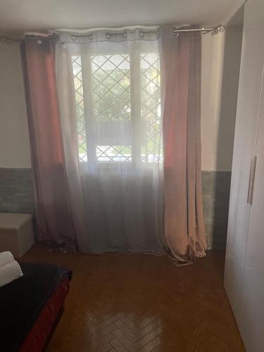 a bedroom with a large window with curtains at Villa Elena appartamento in villa in Montinelle