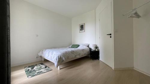 une chambre avec un lit dans une pièce blanche dans l'établissement Appartement 2 pièces entre paris et Disney, à Pontault-Combault