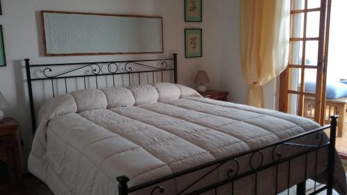ein Schlafzimmer mit einem Bett mit einer weißen Bettdecke in der Unterkunft Sardegnamare&città - La terrazza sul mare in Flumini di Quartu