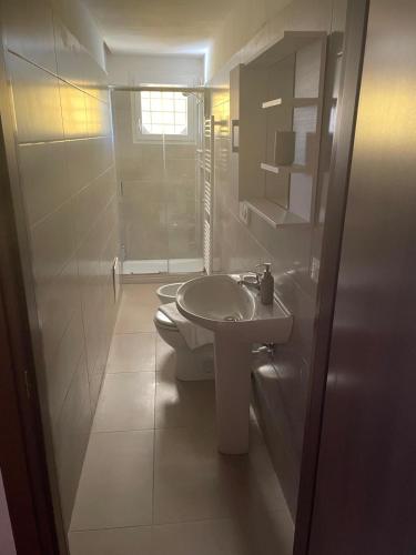 a white bathroom with a toilet and a sink at Villa Elena appartamento in villa in Montinelle