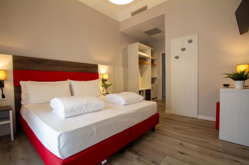 a bedroom with a large bed with a red headboard at Hotel Benacus Torri del Benaco in Torri del Benaco