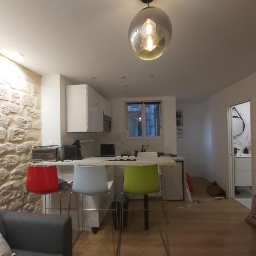 une cuisine avec des chaises colorées et un îlot de cuisine dans l'établissement La Bastille, à Paris