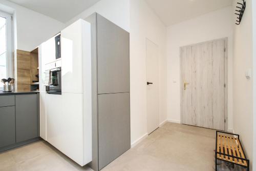 a kitchen with white walls and a gray refrigerator at Apartmán Vita Design in Trenčín