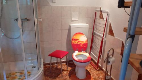a bathroom with a toilet with a painting of a sunset at Ferienwohnung Hähnlein in Steinach