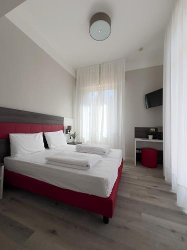 a bedroom with a large bed with a red headboard at Hotel Benacus Torri del Benaco in Torri del Benaco