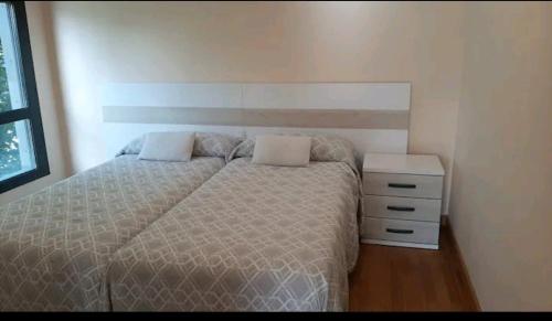 um quarto com uma cama e uma cómoda em El Sermar em Santoña