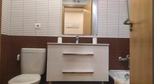 ein Badezimmer mit einem WC, einem Waschbecken und einem Spiegel in der Unterkunft El Sermar in Santoña