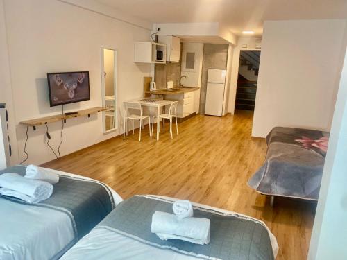sala de estar con 2 camas y cocina en My Pretty Payma Apartamentos, en Benidorm