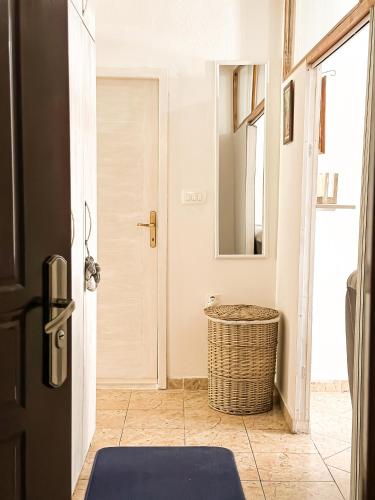 a hallway with a door and a wicker basket at Venera Apartman in Škaljari