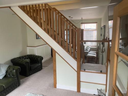 a staircase in a living room with a couch and a chair at Impeccable 3-Bed House in York in York