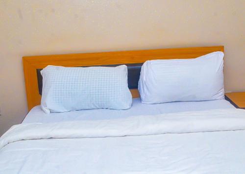 two white pillows sitting on top of a bed at Miccom Golf Hotel and Resort in Ikirun