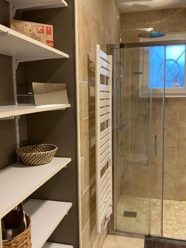 La salle de bains est pourvue d'une douche à l'italienne et d'une douche en verre. dans l'établissement Maison au calme au bord des bois, à Saint-Aubin-de-Médoc