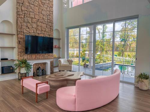 a living room with a fireplace and pink chairs at Lucia Villa - Melorita Hòa Lạc in Hanoi