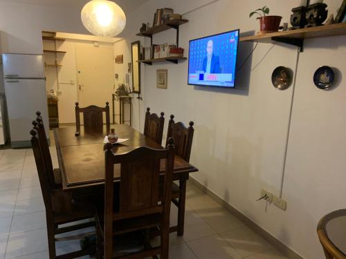 uma sala de jantar com uma mesa e uma televisão na parede em Centro comercial munro em Munro