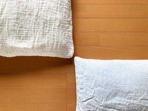 Cama con almohada blanca junto al suelo de madera en sikari Vacation STAY 95401v, en Takashima