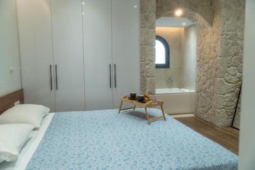 a bedroom with a bed and a table on a blue rug at Carpe Diem Suite in Liapades