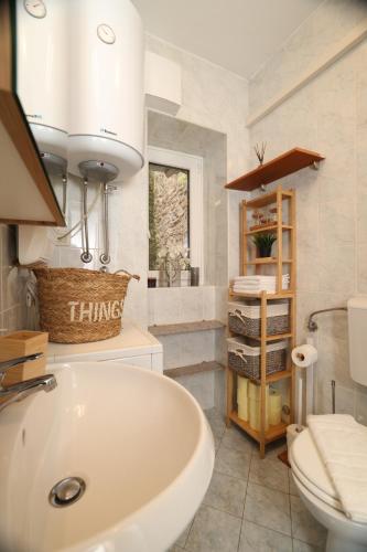 Un baño con lavabo blanco y inodoro. en MHOUSE, en Piran