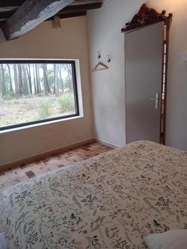 a bedroom with a bed and a window at La maison du rouquet in Le Beausset