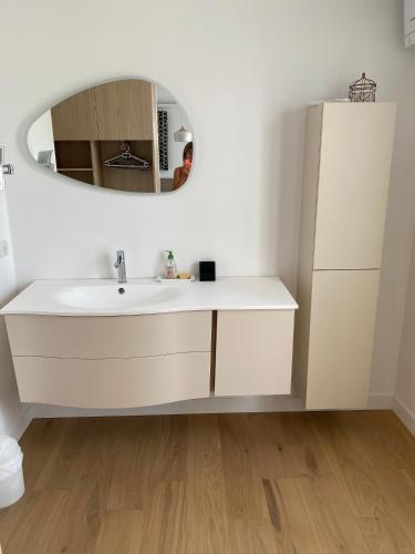 une salle de bain avec un lavabo blanc et un miroir dans l'établissement La villa de Michèle, à Marseillan