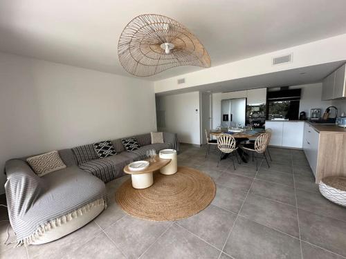 un salon avec un canapé et une table dans l'établissement Magnifique T4 neuf de 90m2 avec jardin et piscine au cœur de Sainte Maxime, à Sainte-Maxime