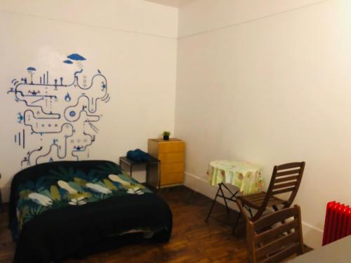ein Schlafzimmer mit einem Bett, einem Tisch und einem Stuhl in der Unterkunft Appartement Porte De Clichy in Clichy