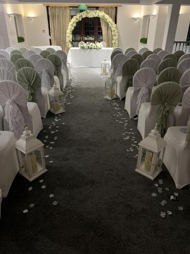 a aisle with white chairs and tables and umbrellas at The Pear Tree Inn & Country Hotel in Worcester