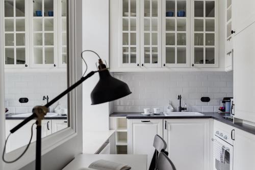 a black lamp in a kitchen with white cabinets at Warsaw Concept in Warsaw