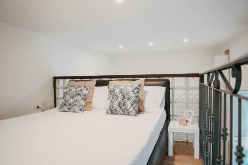 a bedroom with a bed with white sheets and pillows at La casetta di carmé in Naples