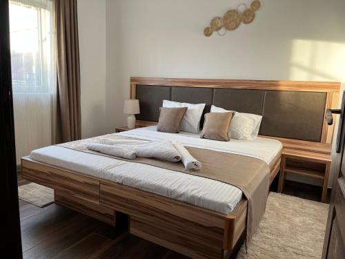 1 dormitorio con 1 cama grande y 2 toallas. en Airport SKY apartments LUX en Belgrado