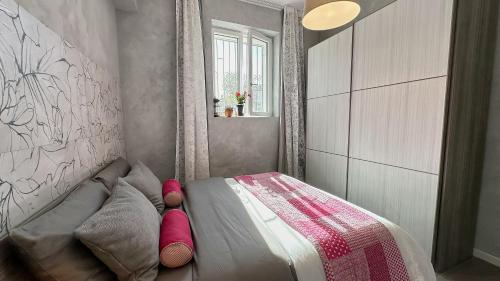 Duck Palace 2 في مونيغا: غرفة نوم صغيرة مع سرير مع وسائد وردية